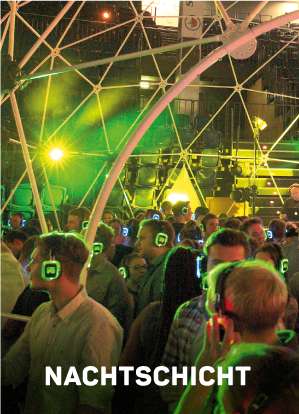 Eine Menschenmenge mit leuchtenden Kopfhörern in einer Silent-Disco unter grünen und gelben Lichtern im Inneren einer geometrischen Kuppelstruktur. Das Wort NACHTSCHICHT erscheint am unteren Rand in fetter weißer Schrift.