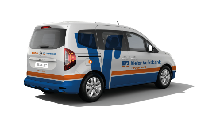 Ein weißer Renault-Kleintransporter mit blauen und orangefarbenen Streifen und dem Schriftzug "Kieler Volksbank E-PowerMobil" an der Seite, von hinten links auf einem einfarbig weißen Hintergrund.